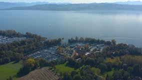 Aerial view of the city Langenargen beside the lake Constance in Germany on a sunny day in autumn, fall. Pan to the left beside the harbor.