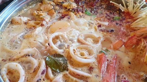 seafood tom yum mix with squid,shrimp, mussel and mushroom boiling in the pot,Thai famous food,video clip.