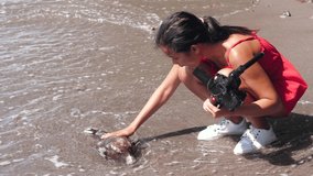 A female vlogger found a dead fish at the seashore when filming video.