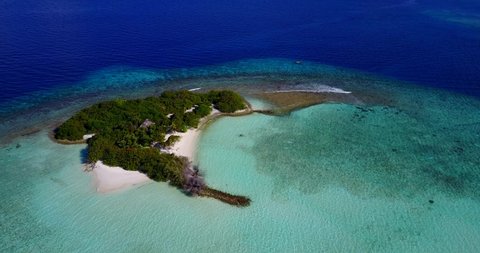 Astonishing view from very high of an isolated tropical island, turquoise lagoon and deep blue sea water in Chagos Archipelago