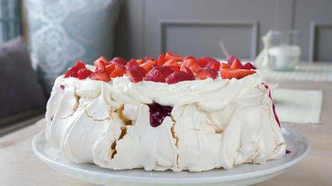 Enormous Pavlova - a meringue dessert with a crisp crust and soft, light inside, topped with strawberries and whipped cream. Rotaryement, clockwise rotation