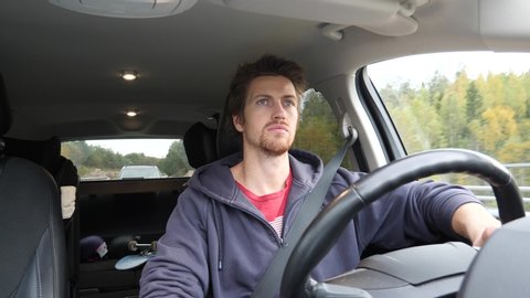 A man drives distracted by talking on a smartphone while driving