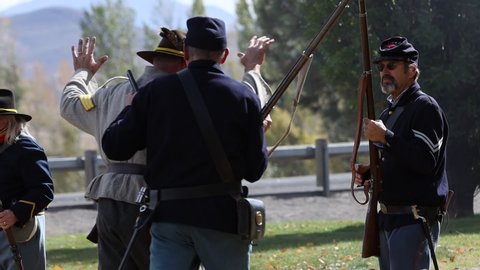 Reno, NV / USA – October 19 2019: Union Civil War Soldiers Take Confederate Prisoner in Slow Motion with Shallow Depth of Field.