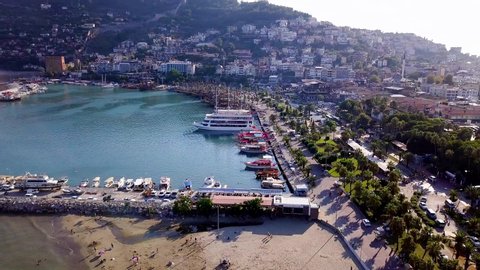 Top view of port with sea vessels at resort mountain town. Clip. Beautiful seaport with yachts and ships in background of city in highlands. Port ships are waiting for new voyage to sea