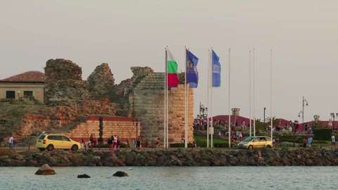 NESSEBAR, BULGARIA - JULY 26 2016: Bulgaria flags, community Nessebar, UNESCO on the background of the ruins in the Old Town of Nessebar, Bulgaria.