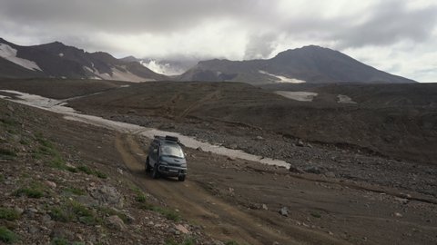 Japanese SUV Mitsubishi Delica driving on mountain road in direction of travel destinations for mountain adventure on active Mutnovsky Volcano. Time lapse. Kamchatka Peninsula, Russia - Aug 16, 2019