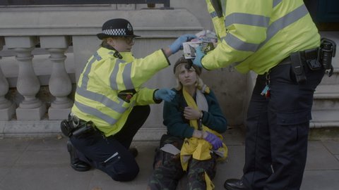 London , London / United Kingdom (UK) - 10 09 2019: Extinction Rebellion, British police officers arresting a young woman demonstrator outside the Cabinet Office on Whitehall road in Westminster.
