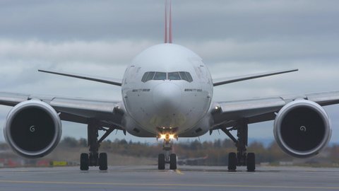 oslo airport norway - ca october 2019: huge airplane taxiing towards camera late evening illuminated headlights ambient sound