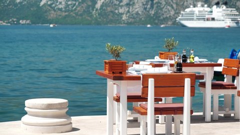 Table in a restaurant with sea view. Bay of Kotor of Adriatic Sea, Montenegro, view on white liner