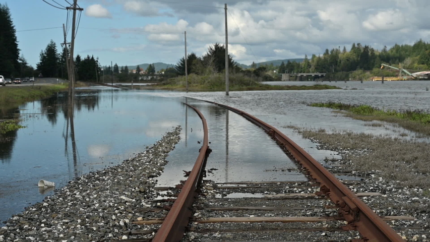 Slow zoom out of flooded railroad tracks due to global warming