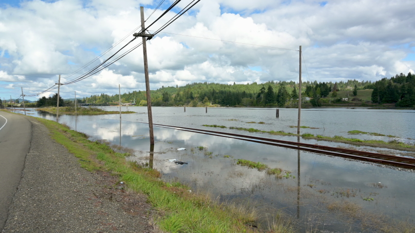 Pan right of flooded railroad tracks due to global warming
