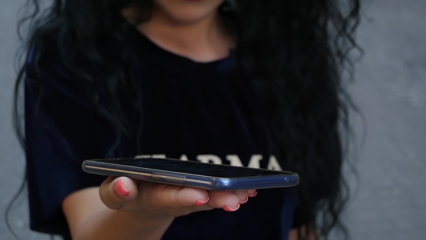 Unrecognizable curly brunette woman showing HUD hologram with text Idea. Girl uses technology of the future on a mobile screen