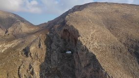 Aerial drone video of small chapel of Panagia Katefiani built uphill, Santorini island, Cyclades, Greece