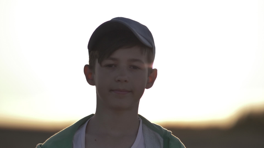 Portrait of a boy in a cap looking at the camera outdoors | Shutterstock HD Video #1039462025