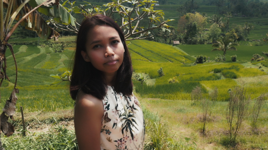 Asian woman spinning around looking at a paddy fields. Bali, Indonesia. Rice plantations