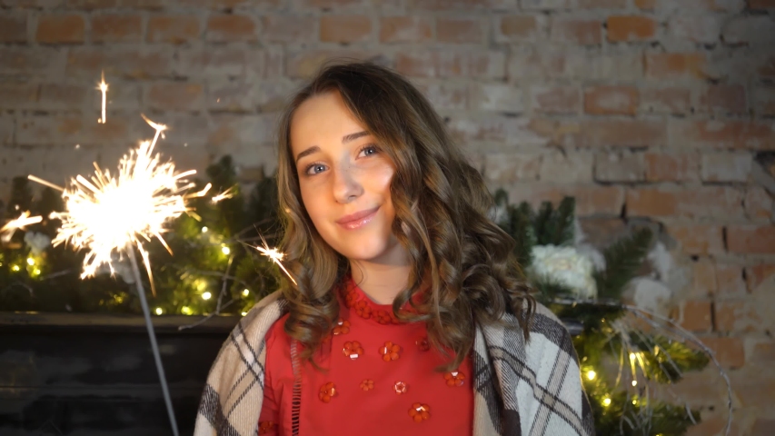 Happy Girl Wearing Dress And Standing With Bengal Lights Near Christmas.