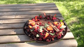 Chocolate and strawberry cake on a wooden table on backyard