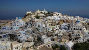 Aerial drone video of iconic small traditional village and uphill castle of Pyrgos with great views to Santorini island Cladera, Cyclades, Greece