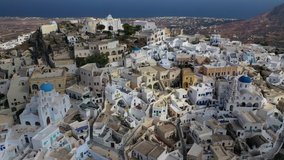 Aerial drone video of iconic small traditional village and uphill castle of Pyrgos with great views to Santorini island Cladera, Cyclades, Greece