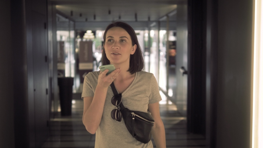 Travel woman using smartphone audio message voice recognition airport. 