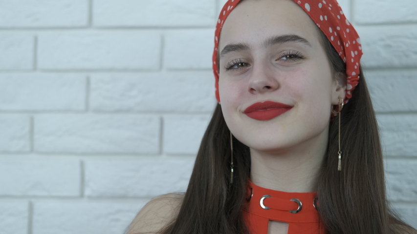 Beautiful girl in a red scarf and red lips.