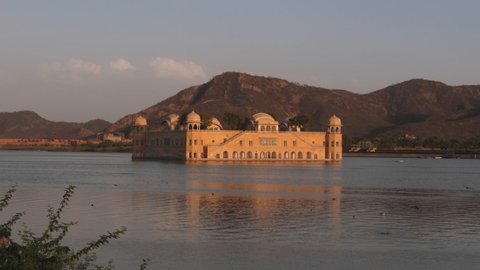 the historic jal mahal palace and lake man sagar at sunset in jaipur, india