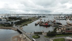 4K aerial early morning sunrise drone video of beautiful Gulf of Finland bay view of commercial port area at ZSD highway high-columns overpass bridge, Kanonerskiy Island, St.Petersburg, Russia