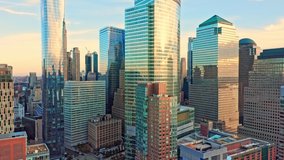 Drone footage with slow pull back away from New York City Lower Manhattan skyscrapers on a sunny afternoon before sunset