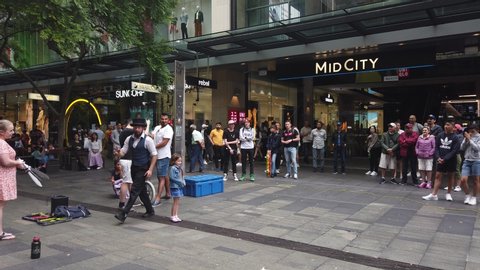 Sydney, Australia - Sept 30 2019: street performer entertain pitt street mall westfield visitors onlooker cheer and clap for stunt performance in public crowd enjoy.  young girl volunteer participate