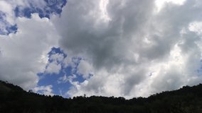 Time lapse video of storm clouds forming above rainforest before rain falls 