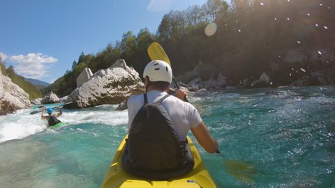 Two guys kayaking on a rough river