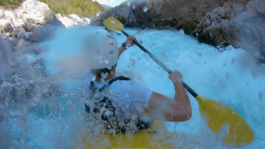 Two friends kayaking through rapids