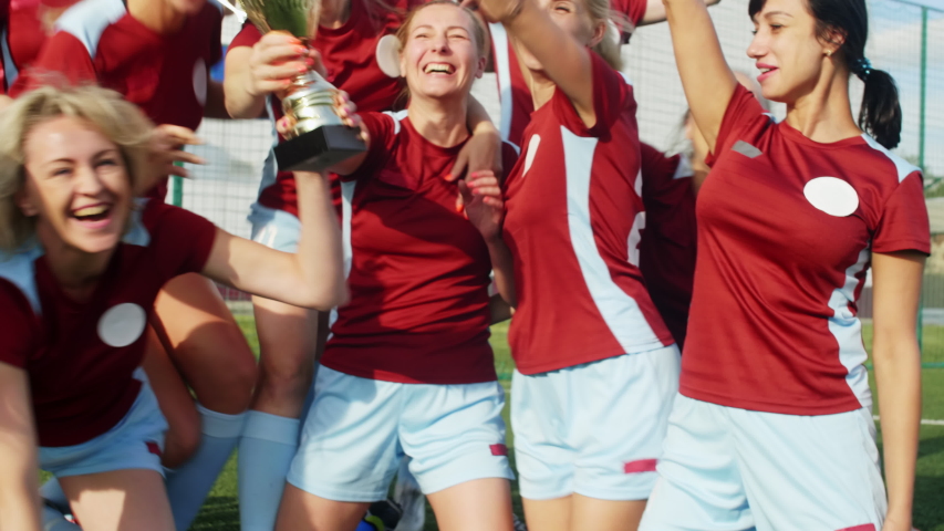 Happy women in soccer sportswear getting Cup, celebrating win and hugging each other Royalty-Free Stock Footage #1039501643