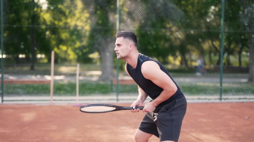 Professional tennis player waiting for serve and hitting the ball at court, medium shot