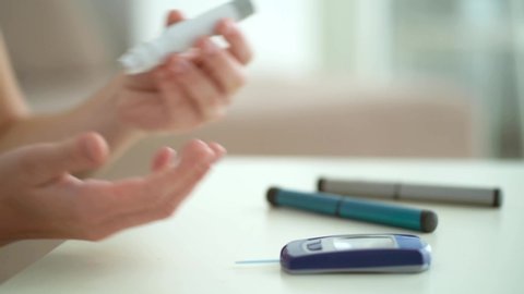 Diabetic patient suffering sugar diabetes measures blood glucose level with a glucometer at home. Health care, diabetic lifestyle