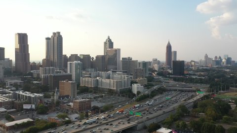 4K Ariel Drone Shot Over Skyline Buildings In Atlanta, Georgia. USA. Pretty Tall Skyline Over Busy Highway Road With Cars Driving Through. Important Tall Buildings, Blue Sky In America