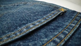 Extreme detailed of blue denim jeans cloth texture in macro dolly shot over the cloth surface. Flow view of clothing material. Textile abstract background. Vintage fashion apparel industry concept.
