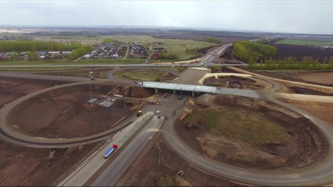 Aerial view construction of a new highway. A drone flies over a construction site with workers and machines