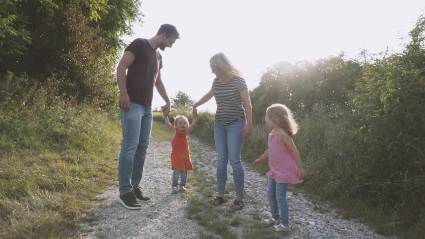 Father and mother walk hand in hand with their two daughters | Shutterstock HD Video #1039524344