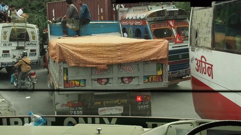Kathmandu / Nepal - 08 31 2019: Busy Chaotic Traffic on Suburban Road, People on Bus and Colorful Truck Roofs