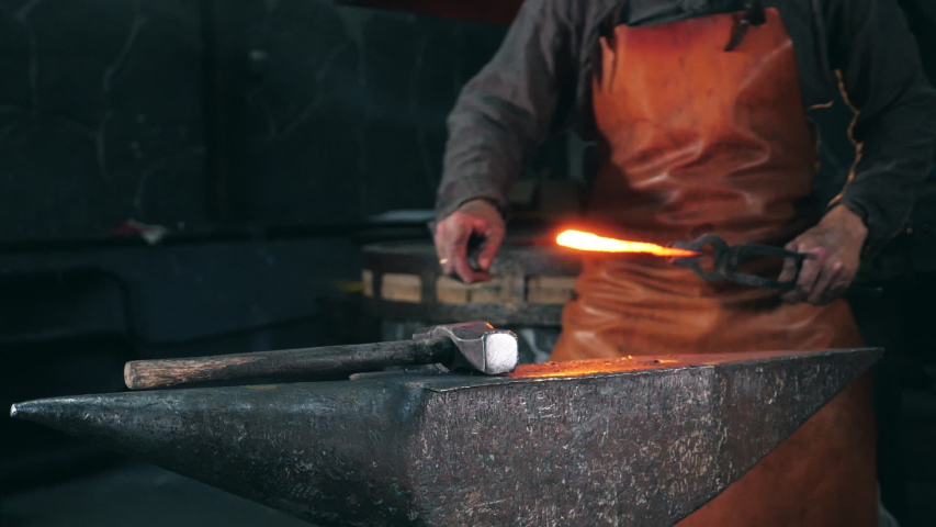 Blacksmith is using hammer to forge metal | Shutterstock HD Video #1039532246