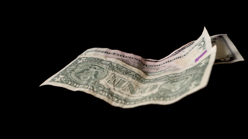 Dollar bills are blown away in front of a black background Royalty-Free Stock Footage #1039533644