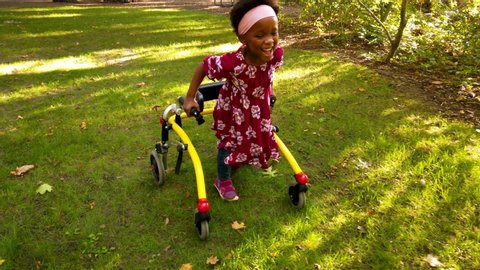 Black girl with Cerebral Palsy walking in the park with her assistive device