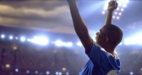 4k footage of a soccer player celebrating victory on a professional outdoor soccer stadium. Players wear unbranded uniform. Stadium and crowd are made in 3D.