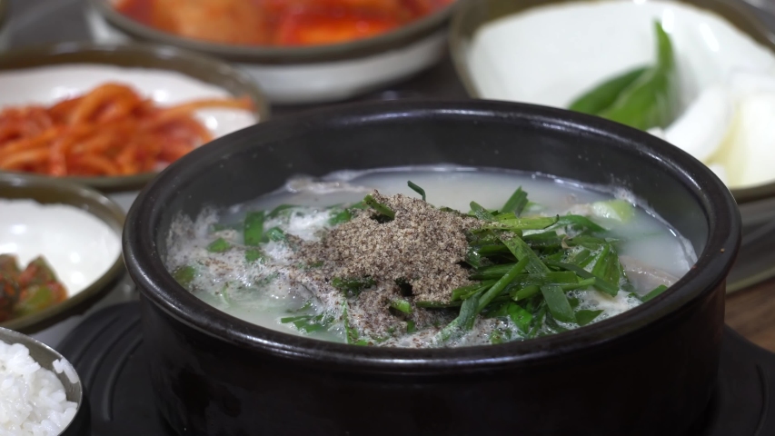 Korean tradition food, sundae gukbap in ttukbaegi,sundae gukbap(boiled rice with Korean sausage and pork),Kimchi and side dish,ttukbaegi( earthen pot) Royalty-Free Stock Footage #1039542482