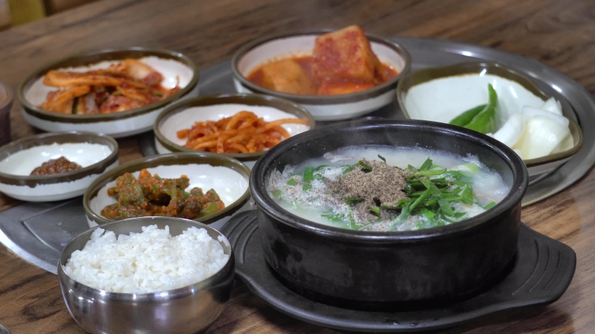 Korean tradition food, sundae gukbap in ttukbaegi,sundae gukbap(boiled rice with Korean sausage and pork),Kimchi and side dish,ttukbaegi( earthen pot) Royalty-Free Stock Footage #1039542485