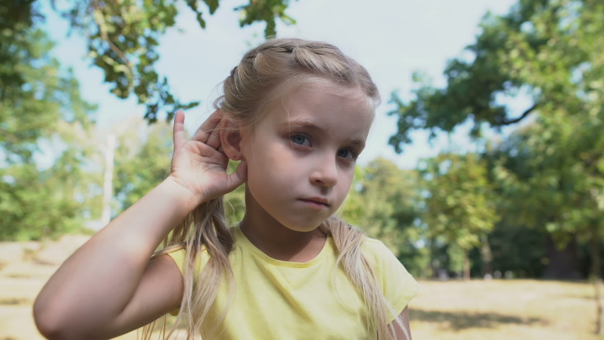 Girl touching ear, eavesdropping gossips, child hearing loss problem, deafness | Shutterstock HD Video #1039556831