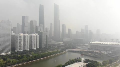 Guangzhou, Chiana - OCT 21 2019: Very dirty air due to smog. In the frame are skyscrapers, a river, a small park area. Bad visibility.