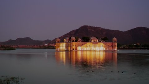 night shot of a beautiful jal mahal palace floodlit in lake man sagar of jaipur, india
