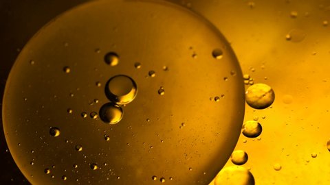 Abstract colorful background. Foam of Soap with Bubbles macro shot. Closeup bubbles in water. Oil drops on a water surface abstract background. Golden yellow bubble. Yellow water bubbles wallpaper.4k 